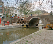 828222 Gezicht op de Vollersbrug te Utrecht, tijdens de restauratie, vanaf de werf aan de westzijde van de Oudegracht.